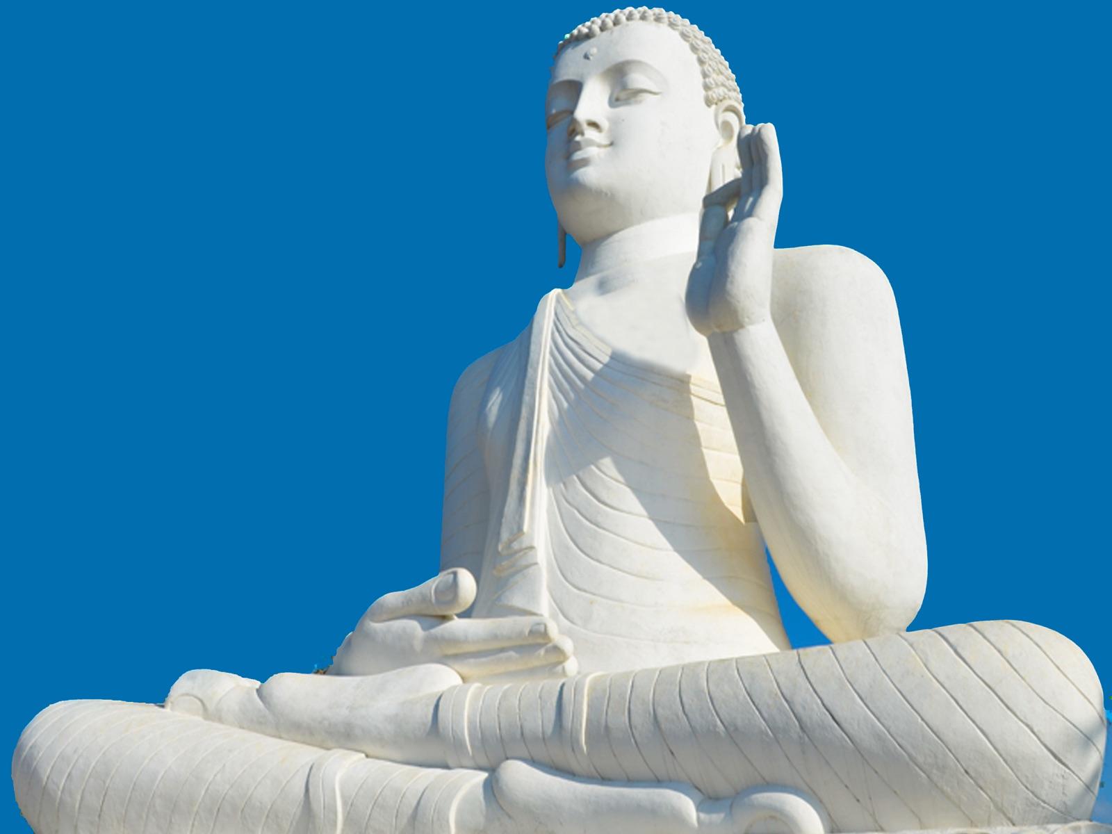 A white Buddha sculpture in zazen meditation posture against open sky